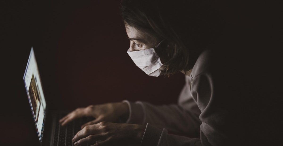 两名玩家在电脑前紧盯屏幕进行双人同屏对战，其中一人手指悬在键盘上方准备操作，屏幕光映在脸上